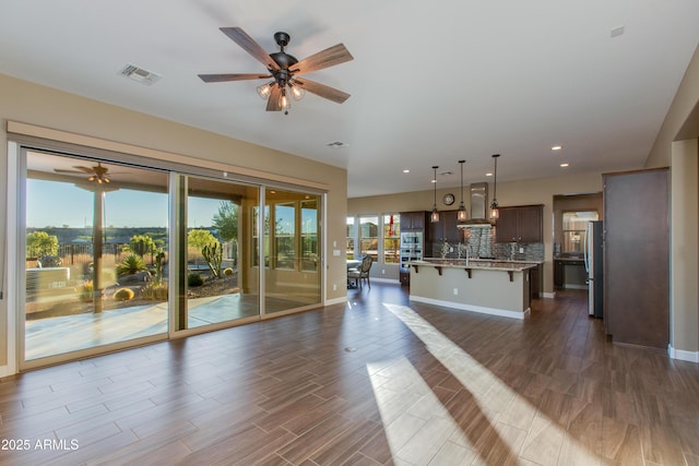 3285 Big Sky Dr, Wickenburg, AZ 85390 - unfurnished living room with a ceiling fan, recessed lighting, baseboards, dark wood-style flooring, and a sink
