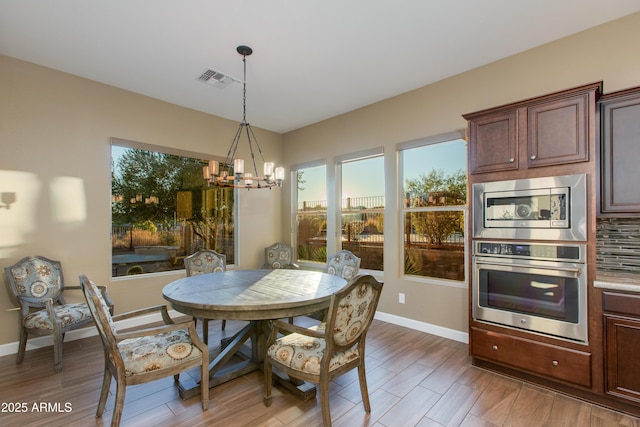 3285 Big Sky Dr, Wickenburg, AZ 85390 - dining area featuring a chandelier, baseboards, and light wood-style floors