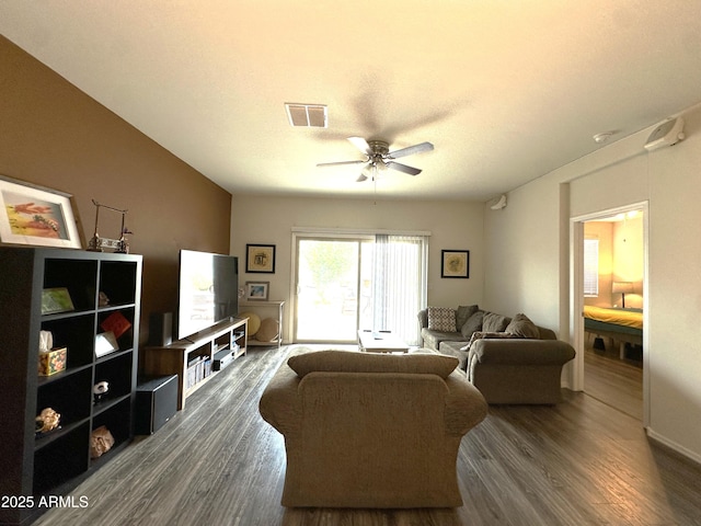 living room featuring a textured ceiling, visible vents, dark wood-style flooring, and a ceiling fan