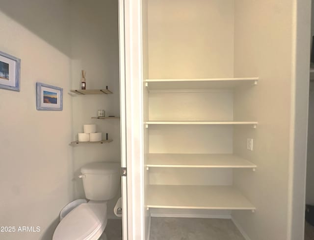 bathroom with baseboards and toilet