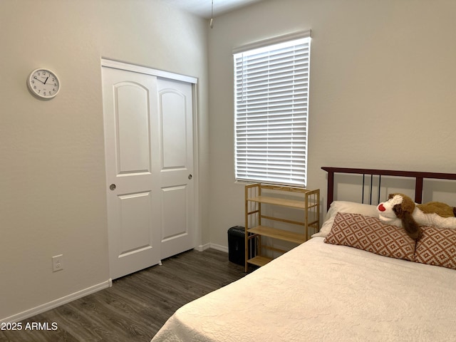 bedroom featuring baseboards, a closet, and dark wood-style flooring