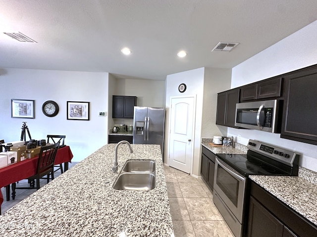 kitchen featuring a sink, visible vents, light stone countertops, and appliances with stainless steel finishes