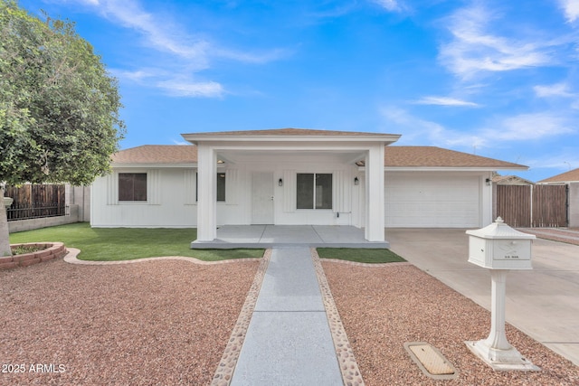 ranch-style house featuring roof with shingles, a porch, concrete driveway, fence, and a garage