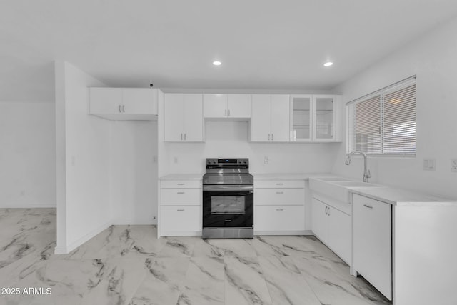 kitchen with recessed lighting, light countertops, white cabinets, stainless steel range with electric cooktop, and a sink