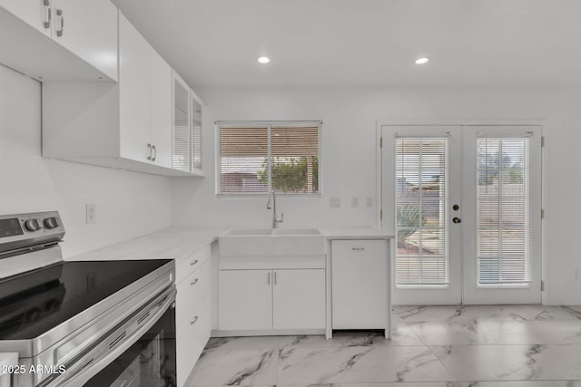 kitchen featuring a sink, a healthy amount of sunlight, stainless steel range with electric cooktop, marble finish floor, and french doors