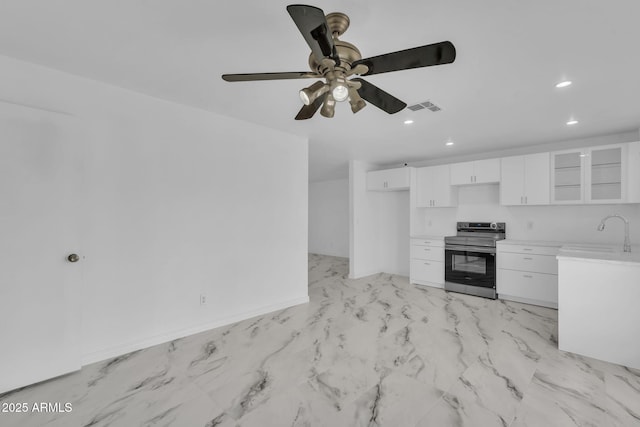 kitchen with visible vents, white cabinets, stainless steel electric stove, light countertops, and a sink