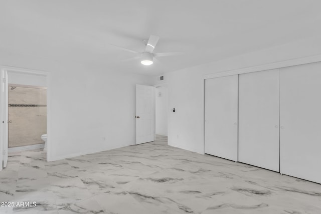 unfurnished bedroom featuring marble finish floor, ceiling fan, a closet, and ensuite bathroom