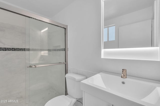 full bathroom featuring a stall shower, a sink, toilet, and tile walls