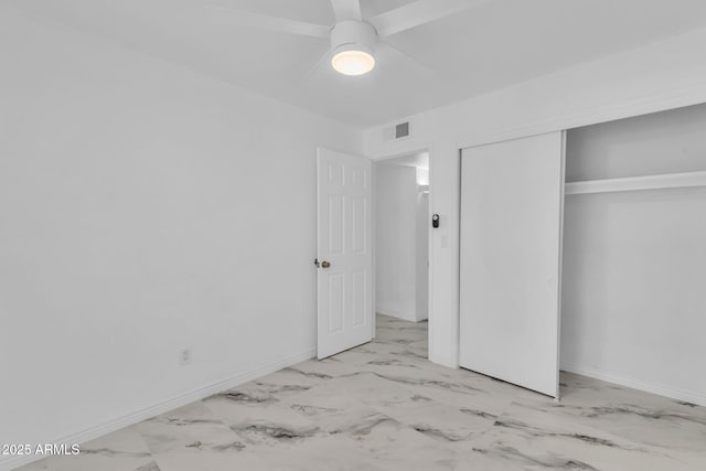 unfurnished bedroom featuring marble finish floor, a closet, visible vents, and baseboards