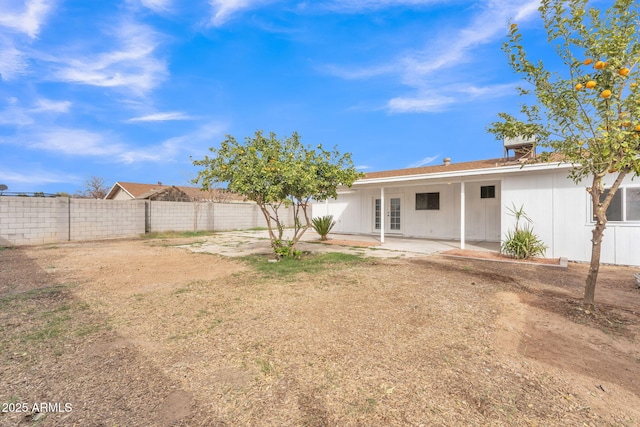 rear view of property featuring a patio and fence