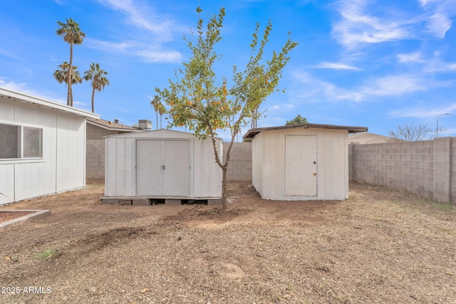 exterior space featuring a fenced backyard, an outdoor structure, and a shed