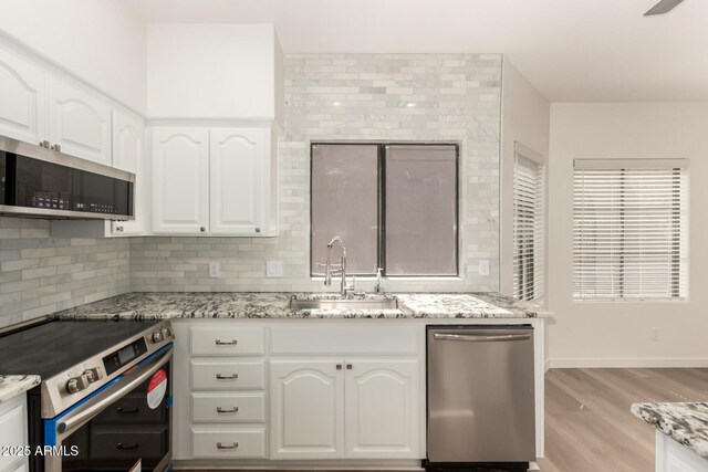 8725 E Via Del Arbor, Scottsdale, AZ 85258 - kitchen featuring stainless steel appliances, decorative backsplash, and light stone counters