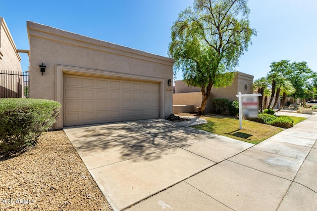 8725 E Via Del Arbor, Scottsdale, AZ 85258 - pueblo-style house with stucco siding, a garage, and concrete driveway