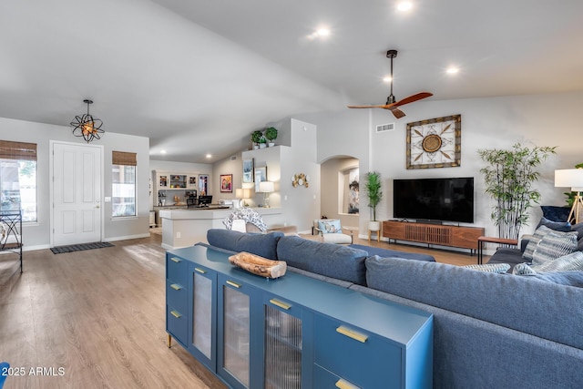 8738 W Runion Dr, Peoria, AZ 85382 - living area featuring arched walkways, light wood finished floors, ceiling fan, lofted ceiling, and baseboards