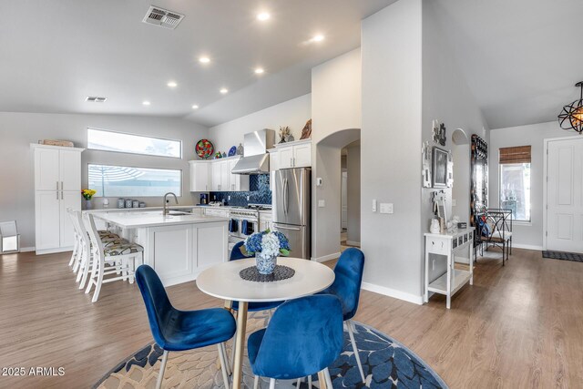 8738 W Runion Dr, Peoria, AZ 85382 - dining space featuring arched walkways, plenty of natural light, light wood-type flooring, recessed lighting, and high vaulted ceiling