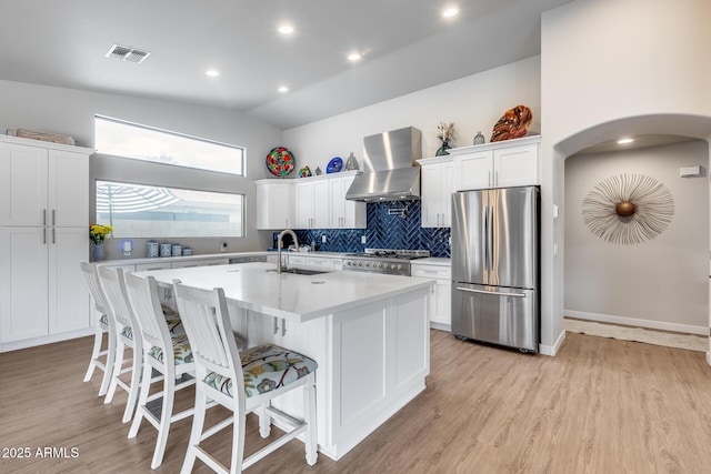 8738 W Runion Dr, Peoria, AZ 85382 - kitchen with freestanding refrigerator, wall chimney range hood, range, light countertops, and white cabinets
