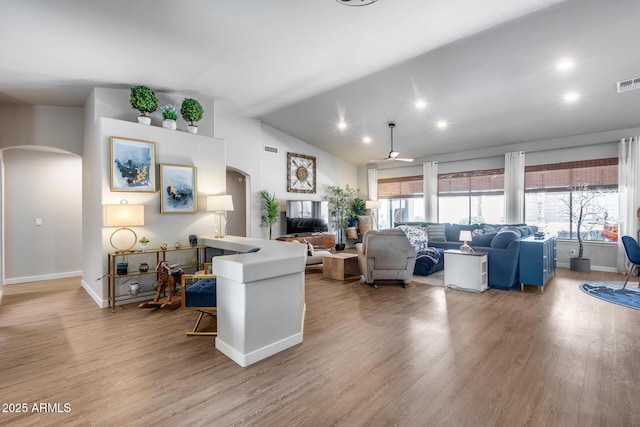 8738 W Runion Dr, Peoria, AZ 85382 - living area featuring arched walkways, wood finished floors, baseboards, vaulted ceiling, and a ceiling fan