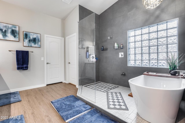 8738 W Runion Dr, Peoria, AZ 85382 - full bathroom with tiled shower, a freestanding bath, wood finished floors, tile walls, and vaulted ceiling
