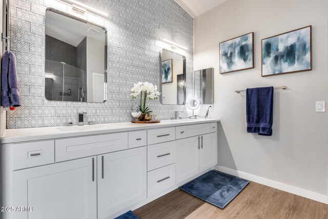 8738 W Runion Dr, Peoria, AZ 85382 - full bathroom featuring double vanity, wood finished floors, baseboards, a shower, and tasteful backsplash