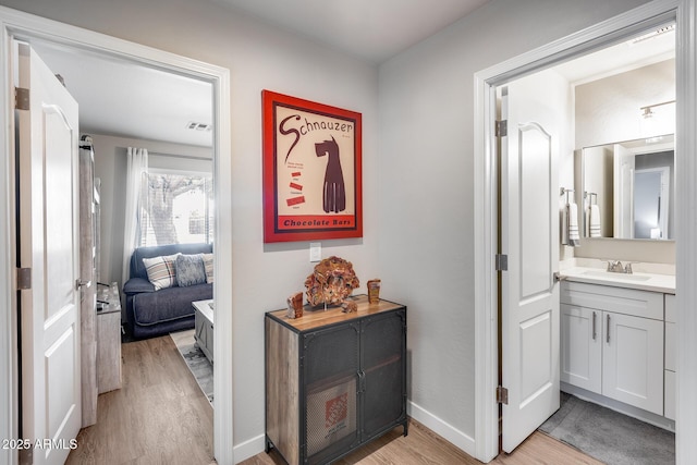 8738 W Runion Dr, Peoria, AZ 85382 - hallway with light wood finished floors, a sink, and baseboards
