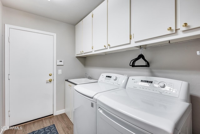 8738 W Runion Dr, Peoria, AZ 85382 - laundry area featuring washing machine and clothes dryer, light wood-style floors, cabinet space, and baseboards