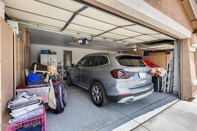 8738 W Runion Dr, Peoria, AZ 85382 - garage with water heater, a garage door opener, and white fridge with ice dispenser