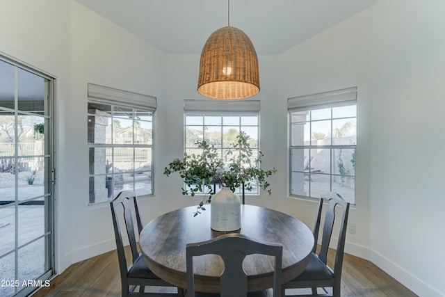 dining space with dark wood-style flooring and baseboards