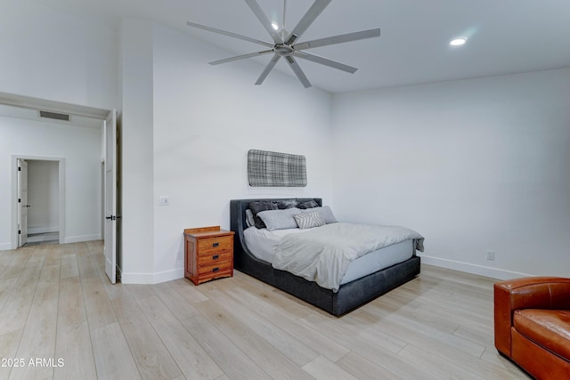 bedroom featuring baseboards, visible vents, ceiling fan, and light wood finished floors