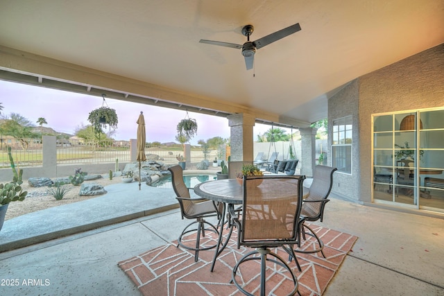 view of patio / terrace featuring a fenced backyard, a fenced in pool, a ceiling fan, and outdoor dining space