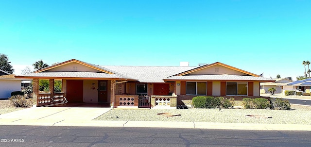 single story home with stucco siding, a carport, roof with shingles, and concrete driveway