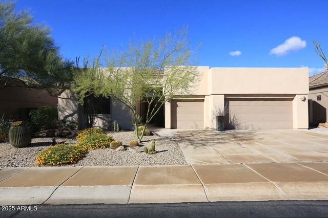 32764 N 68th Pl, Scottsdale, AZ 85266 - pueblo-style house featuring an attached garage, stucco siding, and driveway