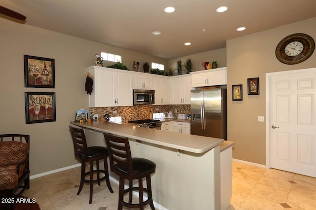 32764 N 68th Pl, Scottsdale, AZ 85266 - kitchen featuring white cabinets, a peninsula, decorative backsplash, and appliances with stainless steel finishes