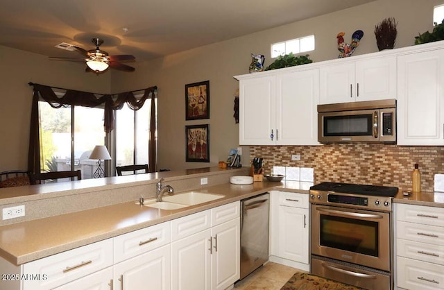 32764 N 68th Pl, Scottsdale, AZ 85266 - kitchen with stainless steel appliances, a peninsula, a sink, a healthy amount of sunlight, and a ceiling fan