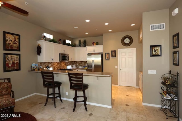 32764 N 68th Pl, Scottsdale, AZ 85266 - kitchen with white cabinets, stainless steel appliances, backsplash, visible vents, and a peninsula