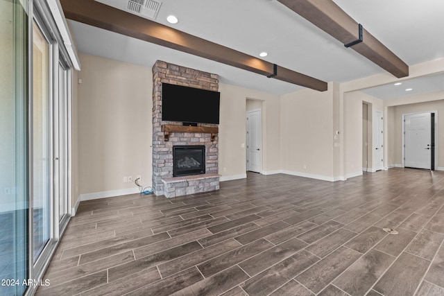 unfurnished living room featuring a fireplace, dark hardwood / wood-style floors, and beam ceiling