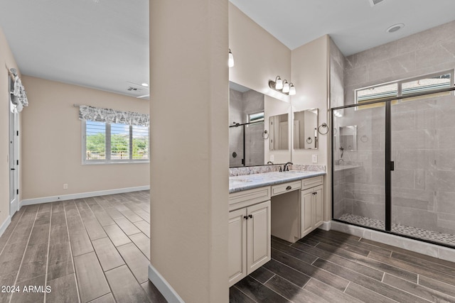 bathroom featuring walk in shower and vanity