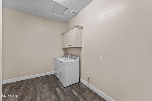 laundry area featuring cabinets, dark wood-type flooring, and washing machine and dryer