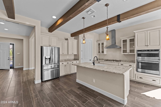 kitchen with light stone countertops, wall chimney range hood, appliances with stainless steel finishes, and dark hardwood / wood-style flooring