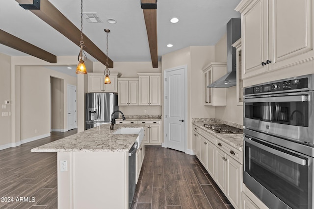 kitchen featuring a kitchen island with sink, sink, appliances with stainless steel finishes, beam ceiling, and decorative light fixtures