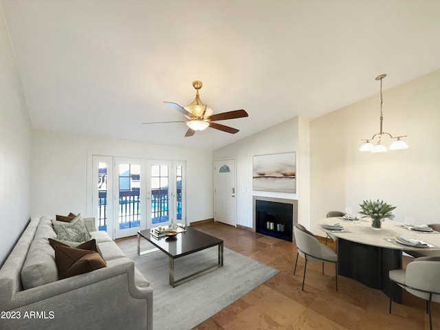 tiled living room featuring lofted ceiling and ceiling fan with notable chandelier