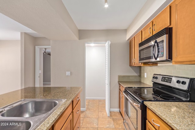 kitchen featuring decorative backsplash, sink, appliances with stainless steel finishes, and light tile patterned floors