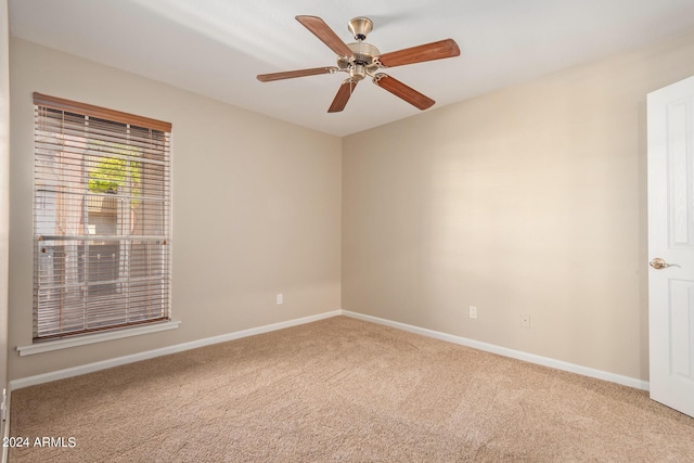 carpeted spare room featuring ceiling fan