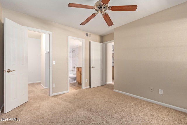 unfurnished bedroom with ensuite bathroom, ceiling fan, and light colored carpet