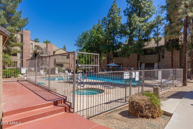 view of swimming pool featuring a patio and a hot tub