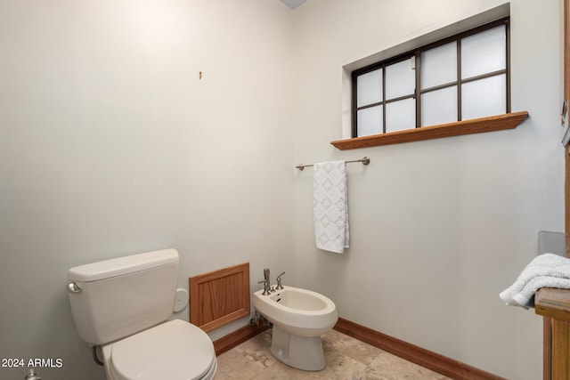 bathroom with a bidet, toilet, and tile floors