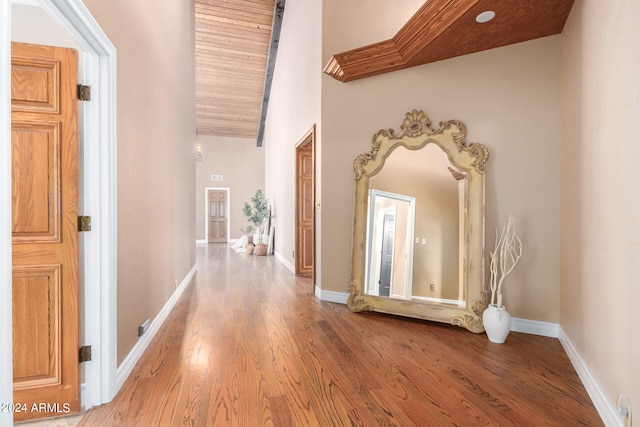 hall with high vaulted ceiling and wood-type flooring