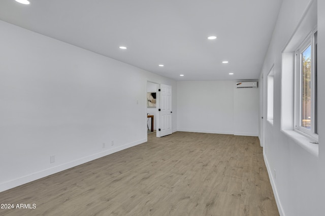 unfurnished room featuring light hardwood / wood-style flooring and a wall unit AC