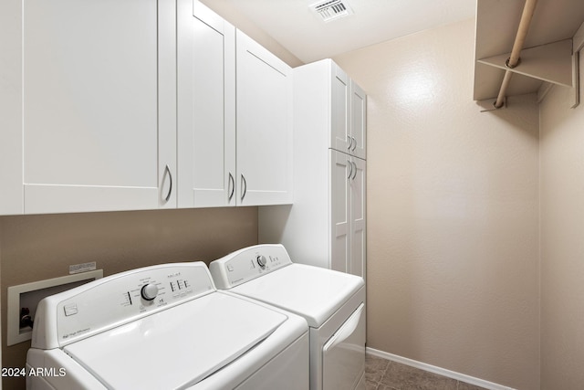 washroom with tile patterned floors, washing machine and dryer, and cabinets