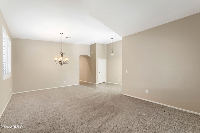 unfurnished room with carpet flooring and a chandelier