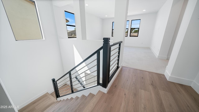 stairway featuring recessed lighting, baseboards, and wood finished floors